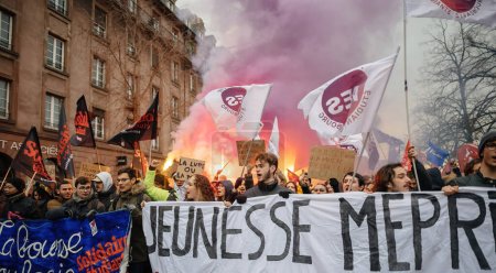 Téléchargez les photos : Strasbourg, France - Jan 19, 2023: Young people with placard, large crowd at protest against the French governments planned pension reform to push the retirement age from 62 to 64 unions have called - en image libre de droit
