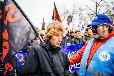 Foto de Strasbourg, France - Jan 19, 2023: French man in front of large crowd at protest against the French governments planned pension reform to push the retirement age from 62 to 64 unions have called for - Imagen libre de derechos