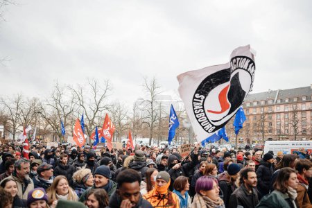 Téléchargez les photos : Strasbourg, France - Jan 19, 2023: Large crowd with flags at protest against the French governments planned pension reform to push the retirement age from 62 to 64 unions have called for mass social - en image libre de droit