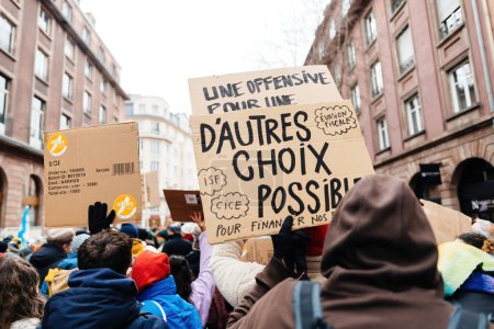 Téléchargez les photos : Strasbourg, France - Jan 19, 2023: Placard with proposal to other choises possible to finance the pension reforms - Large crowd at protest against the French governments planned pension reform to - en image libre de droit