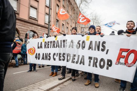 Téléchargez les photos : Strasbourg, France - Jan 19, 2023: Colleagues holding large banner at protest against the French governments planned pension reform to push the retirement age from 62 to 64 unions have called for - en image libre de droit