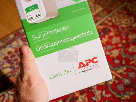 Photo for Frankfurt, Germany - Dec 2, 2022: POV male customer hand holding APC American Power Conversion Corporation by Schneider Electric cardboard package with Life is on slogan - Royalty Free Image