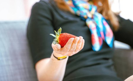 Foto de Elegant female hand holding single strawberry - Imagen libre de derechos