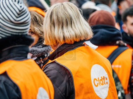 Téléchargez les photos : Strasbourg, France - 31 January 2023: Rear view of woman in orange CFDT west at second demonstration against the new pension reform to be presented next month by French Prime Minister Elisabeth Borne - en image libre de droit
