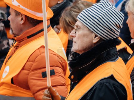 Foto de Strasbourg, France - 31 January 2023: Side portarit of adult man holding flag at second demonstration against the new pension reform to be presented next month by French Prime Minister Elisabeth Borne - Imagen libre de derechos