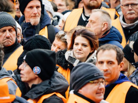 Foto de Strasbourg, France - 31 January 2023: One French woman between mens at second demonstration against the new pension reform to be presented next month by French Prime Minister Elisabeth Borne - Imagen libre de derechos