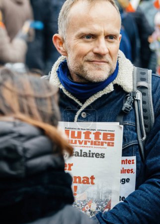 Photo for Strasbourg, France - 31 January 2023: Man with Lutte Ouvriere magazine at second demonstration against the new pension reform to be presented next month by French Prime Minister Elisabeth Borne - Royalty Free Image