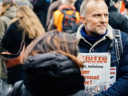 Foto de Strasbourg, France - 31 January 2023: Man with Lutte Ouvriere magazine at second demonstration against the new pension reform to be presented next month by French Prime Minister Elisabeth Borne - Imagen libre de derechos