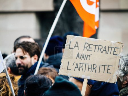 Photo for Strasbourg, France - 31 January 2023: La retraite avant larthrite - retirement before arthritis placard at second demonstration against the new pension reform to be presented next month by French - Royalty Free Image