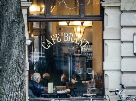 Foto de Strasbourg, France - 31 January 2023: People sitting insde Cafe Brant iconic cafe in central Strasbourg drinking a coffee eating desserts and breakfast - Imagen libre de derechos