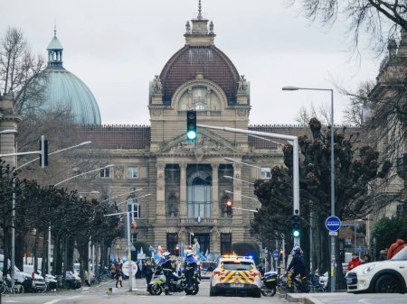 Téléchargez les photos : Strasbourg, France - 31 January 2023: Police and protesters in front of The Palais du Rhin, the former Kaiserpalast, building situated in the German quarter of Strasbourg dominating the Place de la - en image libre de droit