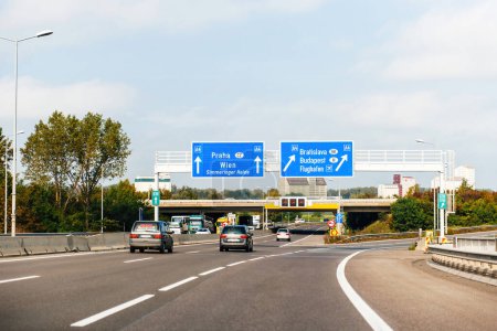 Photo for Austria - Sep 30, 2014: View from the highway at the blue direction signs above with Praha, Wien, Simmeringer haide, Bratislava, Budapest and Airport Flughafen A4 - driving in Austria near the border - Royalty Free Image