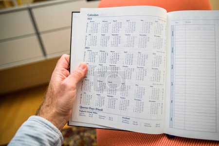 Foto de Male hand holding annual agenda with Calendar for 2022, 2023 and 2024 years - Imagen libre de derechos