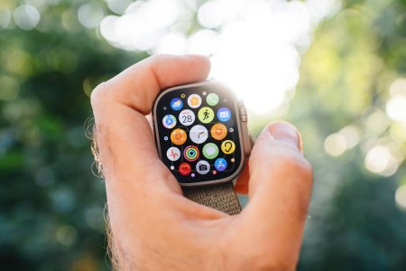 Téléchargez les photos : London, United Kingdom - Sept 28, 2022: Close-up of New Apple Watch Ultra smartwatch in user male hand with all apps applications on the compass app on the retina display - defocused bokeh green - en image libre de droit