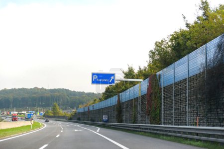 Téléchargez les photos : Rastplats signalisation à droite - traduit par des espaces de repos sur l'autoroute autrichienne avec belle forêt verte en arrière-plan - en image libre de droit