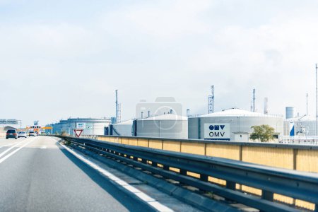 Téléchargez les photos : Vienne, Asutria - 30 sept. 2014 : Vue en perspective sur l'autoroute à côté des multiples grands réservoirs d'essence, de pétrole et de gaz à la raffinerie de pétrole OMV Austria Schwechat - en image libre de droit