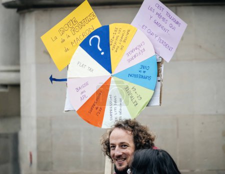 Téléchargez les photos : Strasbourg, France - 31 January 2023: Placards with Wheel of Fortune of Macron at second demonstration against the new pension reform to be presented next month by French Prime Minister Elisabeth - en image libre de droit