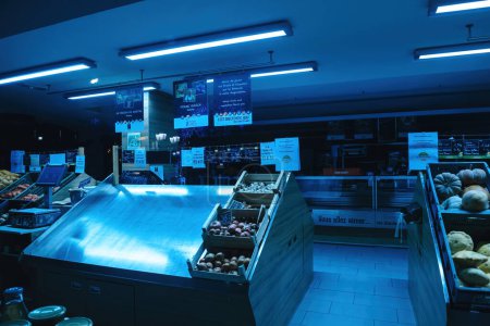 Foto de Estrasburgo, Francia - 19 de diciembre de 2022: Color azul sobre un supermercado biológico alsaciano vacío cerrado con verduras vacías y estantes de frutas - Imagen libre de derechos