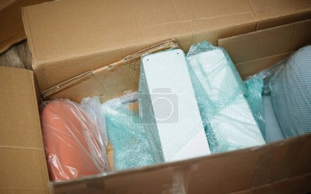 Photo for Large cardboard box with multiple metallic parts of luxury comfortable lounge chairs furniture online purchases - Royalty Free Image