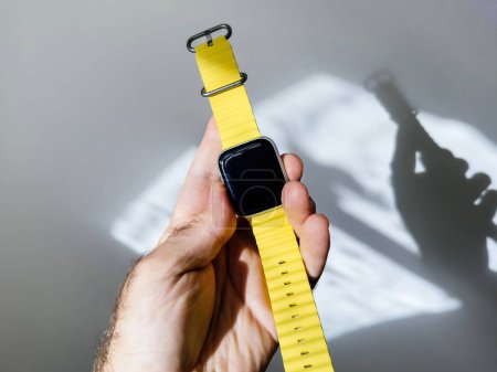 Téléchargez les photos : Paris, France - 23 sept. 2022 : Un client heureux tenant une nouvelle bande de silicone de plongée Apple Watch Ultra attachée à une vieille montre connectée série 4 iot - en image libre de droit