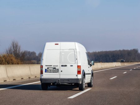 Photo for Germany - Circa 2023: Rear view of white Ford Transit connect mini van on the almost empty highway on a winter day - commuting driving in germany - Royalty Free Image
