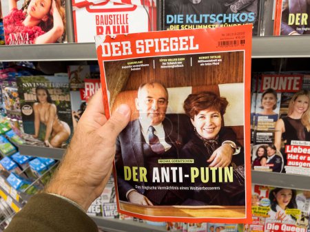 Foto de Frankfurt, Germany - Sep 3, 2022: POV male hand buying latest newspaper magazine Der Spiegel with Mikhail Sergeyevich Gorbachev and his wife Raisa and title - The Anti-Putins - Imagen libre de derechos