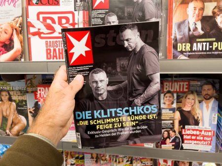 Téléchargez les photos : Francfort, Allemagne - 3 sept. 2022 : Un homme POV achète sa dernière revue de journal à la poupe avec des portraits article sur les frères Wladimir et Vitali Klitschko - en image libre de droit
