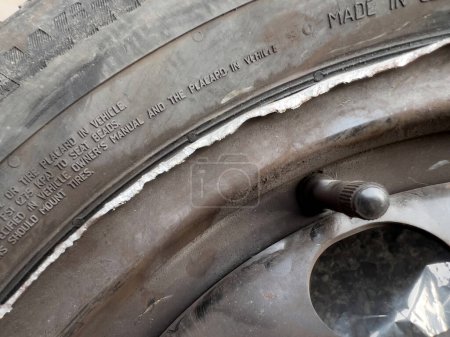 Foto de Clermont-Ferrand, Francia - 17 de octubre de 2022: Neumático de invierno dañado montado en una nueva rueda de rhim después de un accidente - Imagen libre de derechos