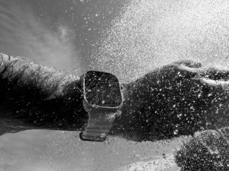 Téléchargez les photos : Paris, France - 23 sept. 2022 : Des éclaboussures d'eau en noir et blanc dans la piscine Plongée manuelle masculine avec une nouvelle Apple Watch Ultra en titane conçue pour des activités extrêmes comme les sports d'endurance, l'élite - en image libre de droit