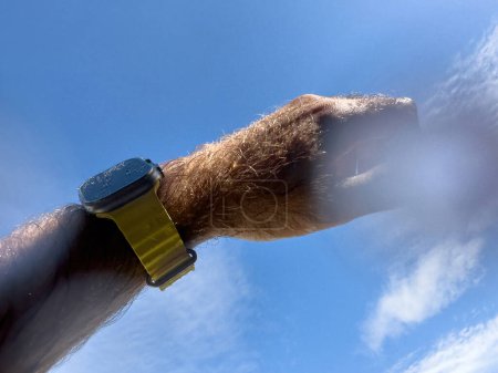 Téléchargez les photos : Paris, France - 23 sept. 2022 : Un homme levé vers le ciel bleu lors d'une baignade pov avec une nouvelle Apple Watch Ultra en titane conçue pour des activités extrêmes comme les sports d'endurance, les athlètes d'élite - en image libre de droit