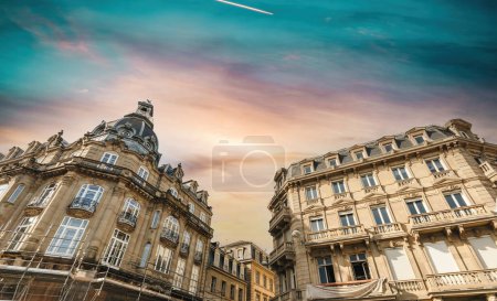 Photo for Low-angle view of tall luxury haussmannian buildings - French city with renovation scaffoldings - construction renovation - dramatic sky - Royalty Free Image