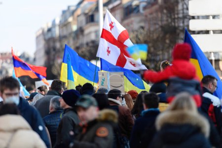 Téléchargez les photos : Strasbourg, France - 6 mars 2022 : Vue arrière des personnes arborant des drapeaux géorgien et ukrainien devant le consulat russe en solidarité avec les Ukrainiens et contre la guerre après l'invasion russe - en image libre de droit