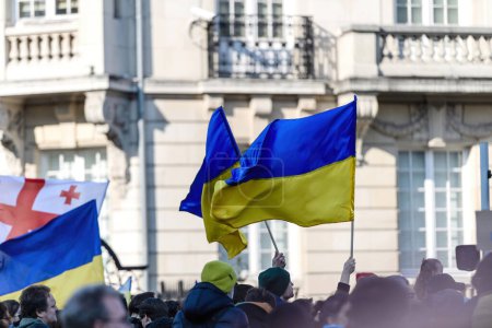 Photo for Strasbourg, France - Mar 6, 2022: People with Ukrainian flags in front of Russian Consulate in solidarity with Ukrainians and against the war after Russian invasion - Royalty Free Image