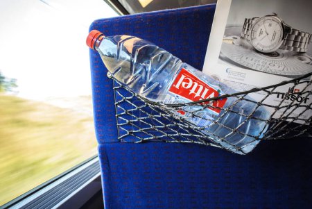 Foto de Suiza - 17 de julio de 2014: Interior de un tren de movimiento rápido con asiento delantero de paso que sostiene la botella de agua potable Vittel de Vittel, propiedad de la empresa suiza Nestlé - Imagen libre de derechos