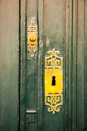 Photo for An aged, vintage old green wooden door with a metal lock in Provence France provides security and protection from unwanted communication. - Royalty Free Image