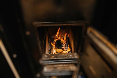 Photo for Wood burning inside black kachelofen heating the house during gas prices rising - Royalty Free Image