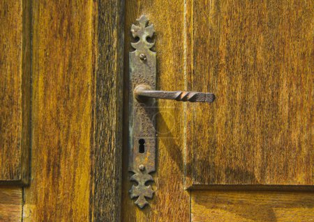 Téléchargez les photos : Ancienne poignée de porte vintage sur une porte en bois - recouverte de rouille et le temps passe - en image libre de droit