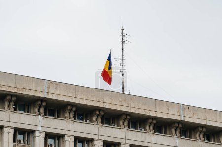 Foto de La vibrante bandera tricolor rumana ondea en la brisa: rayas rojas, amarillas y azules que representan la unidad y la independencia - Imagen libre de derechos