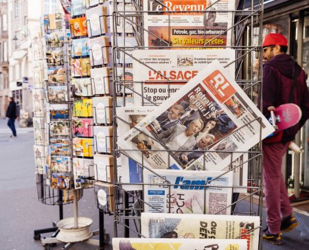 Foto de París, Francia - 20 de marzo de 2023: Los peatones caminan cerca del quiosco de prensa con múltiples periódicos franceses con Elisabeth Borne y votan la reforma de las pensiones buscada por el gobierno francés que - Imagen libre de derechos