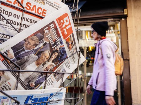 Foto de París, Francia - 20 de marzo de 2023: Adultos caminando cerca del quiosco de prensa con varios periódicos franceses con Elisabeth Borne y votando a favor de la reforma de las pensiones buscada por el gobierno francés que aumentaría - Imagen libre de derechos