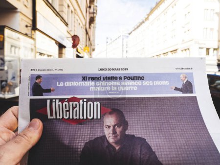 Photo for Paris, France - Mar 20, 2023: Male hand reading Liberation newspaper with French Democratic Confederation of Labour leader Laurent Berger and Putin meeting China President Xi on the cover - Royalty Free Image