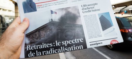 Foto de París, Francia - 20 de marzo de 2023: El espectro de la radicalización - retirarse - título del periódico Les Echos leído por los hombres en la mano - Imagen libre de derechos