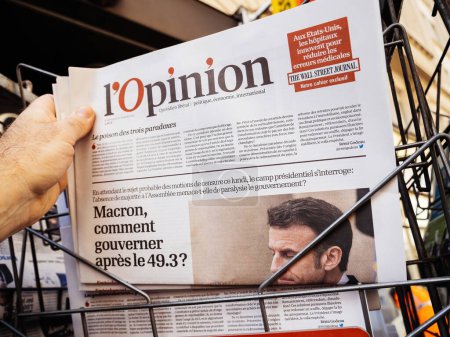Téléchargez les photos : Paris, France - 20 mars 2023 : lopinion titre en main d'un homme au kiosque de presse - Macron, comment gouverner après 49.3 - en image libre de droit