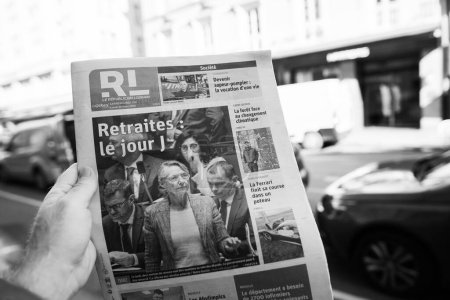 Photo for Paris, France - Mar 20, 2023: Monchrome image - POV male hand buy press reading Le republicain Lorrain featuring Elisabeth Borne and votes pension reform wanted by the French government which would - Royalty Free Image