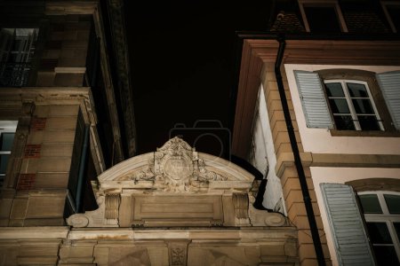 Photo for A vintage house from the past illuminated in a night shot with flash photography, showcasing its beautiful architecture and built structure. Ts monogram on the facade - Royalty Free Image