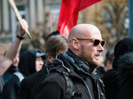 Foto de Strasborg, Francia - 29 de marzo de 2023: Un grupo diverso de adultos, en su mayoría hombres, se une en una multitud unificada para protestar por el aumento de la edad de jubilación - Imagen libre de derechos