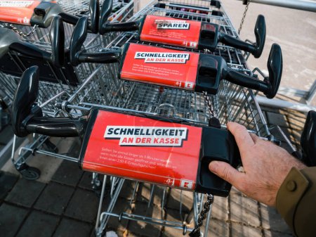 Foto de Alemania - 3 de marzo de 2023: Una persona empujando un carro vacío sin comestibles y artículos para el hogar a través de Kaufland, un supermercado alemán, para comprar artículos a la venta - Imagen libre de derechos