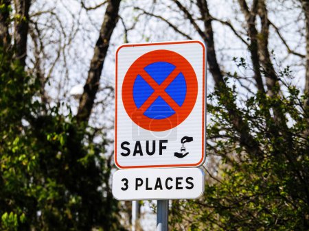 Photo for A warning sign with clear text and a tree in the background stands alone on an empty road, providing guidance to drivers during the day parking allowed only for three cars - French sign - Royalty Free Image