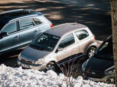 Téléchargez les photos : Allemagne - 10 février 2023 : Mini Toyota argentée, garée près de la neige, offre une vue unique sur ce mode de transport hivernal froid. - en image libre de droit