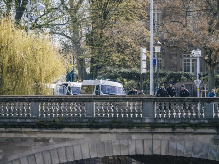 Téléchargez les photos : Strasbourg, France - 29 mars 2023 : Des policiers à Strasbourg, en France, arpentent la ville lors d'une manifestation de leur structure construite sur la voie navigable, entourée d'architecture et d'arbres. - en image libre de droit